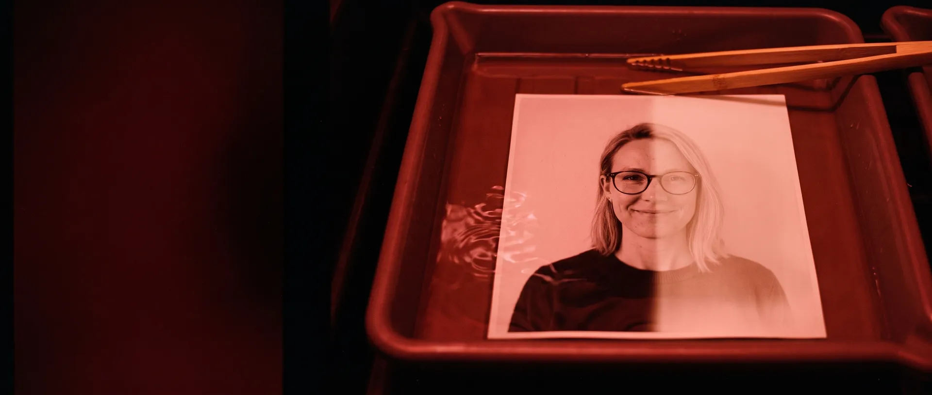Ett foto av Kim Testsson, en påhittad person, som framkallas i ett mörkrum.